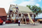 Am fertig ausgemauerten Rohbau des Fachwerkhauses wird die Dachschalung angebracht.