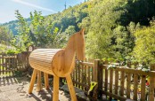 Ein Holzpferd zum Voltigieren lernen, der Gartenzaun und das Vogelhäuschen